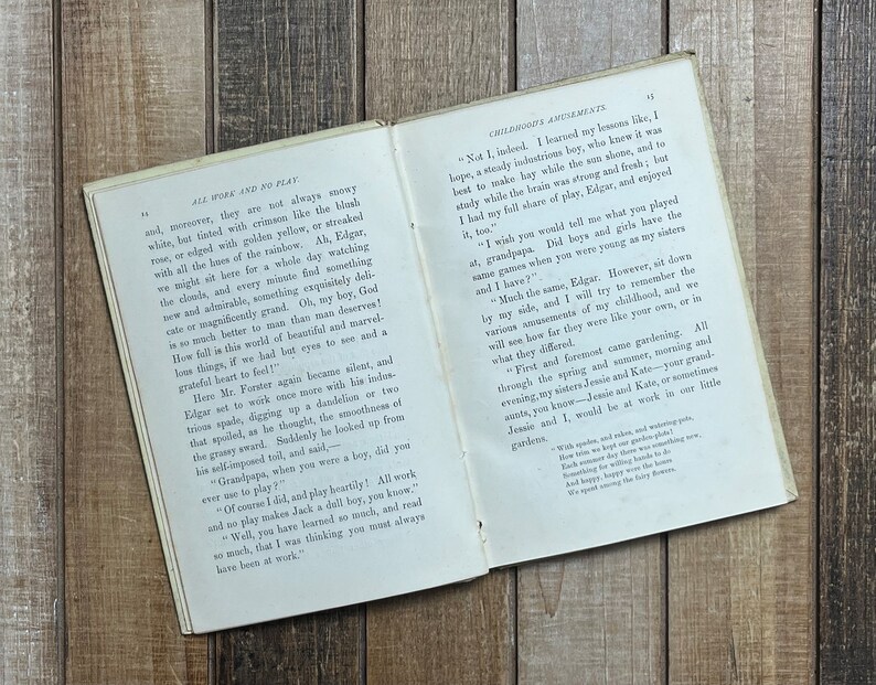 May include: An open book with yellowed pages and a brown leather cover. The book is titled "All Work and No Play" and features text about the importance of play and the beauty of nature. The book is open to a page with the text "Not I, indeed. I learned my lessons like, I hope, a steady industrious boy, who knew it was best to make hay while the sun shone, and to study while the brain was strong and fresh; but I had my full share of play, Edgar, and enjoyed it, too."