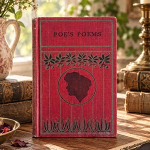 May include: A red hardcover book titled POE'S POEMS with a black silhouette of a person's profile inside a circular frame. The cover features black botanical illustrations of hanging leaves and stems, with thin vertical lines extending to the bottom.