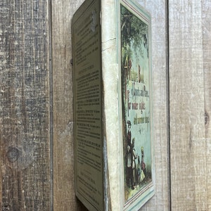 May include: A vintage children's book titled "A Picture Book of Sports and Plays for Winter Nights and Summer Days". The cover features a colorful illustration of children playing in a snowy forest.