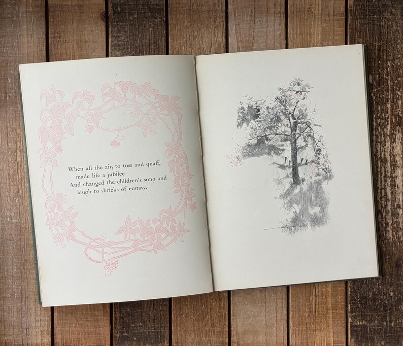 May include: An open book with two pages. The left page features a light pink floral border surrounding the text: When all the air, to toss and quaff, made life a jubilee And changed the children's song and laugh to shrieks of ecstasy. The right page shows a grey ink illustration of a tree.