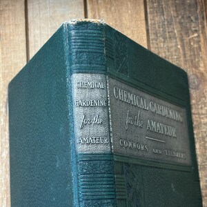 May include: A vintage hardcover book titled "Chemical Gardening for the Amateur" by Connors and Tiedjens. The book has a dark green cover with embossed text and a decorative spine. The book's edges show signs of wear.