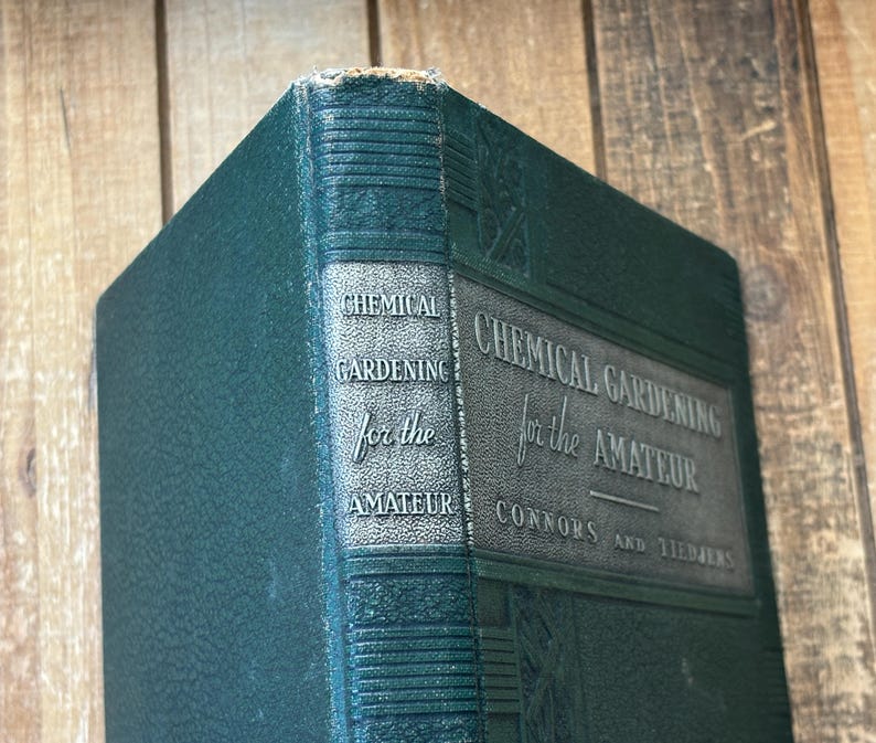 May include: A vintage hardcover book titled "Chemical Gardening for the Amateur" by Connors and Tiedjens. The book has a dark green cover with embossed text and a decorative spine. The book's edges show signs of wear.