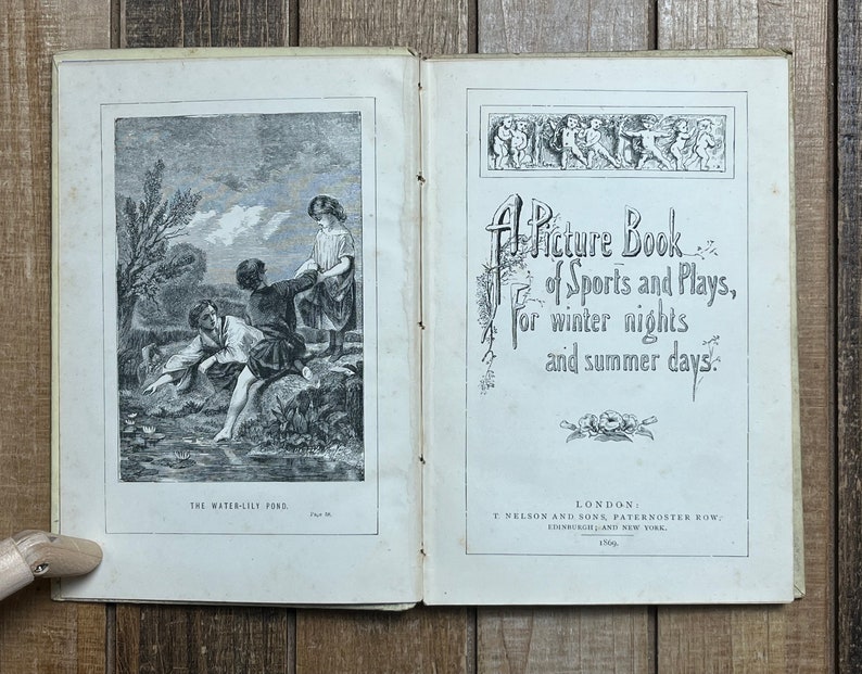 May include: A black and white illustration of a book titled "A Picture Book of Sports and Plays, for winter nights and summer days." The book is open to a page with a black and white illustration of three children playing by a pond.