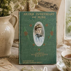 May include: A green hardcover book titled An Old Sweetheart of Mine by James Whitcomb Riley, illustrated by Howard Chandler Christy. The cover features a central oval portrait of a person, gold embossed lettering, and decorative floral vine details.