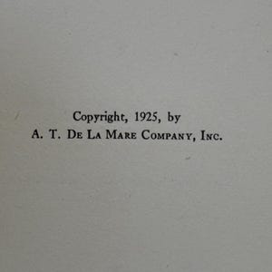 May include: A white page featuring black printed text that reads: Copyright, 1925, by A. T. DE LA MARE COMPANY, INC. The text is centered on the page and uses a serif font. The background is a plain, light-colored paper surface with a subtle texture.