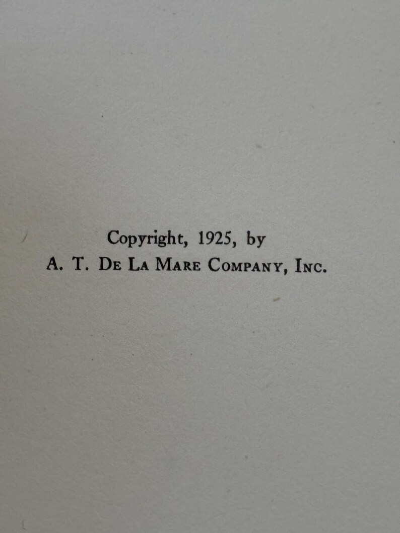 May include: A white page featuring black printed text that reads: Copyright, 1925, by A. T. DE LA MARE COMPANY, INC. The text is centered on the page and uses a serif font. The background is a plain, light-colored paper surface with a subtle texture.