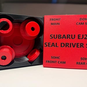 May include: A red Subaru EJ25 Seal Driver Set with components in a black tray. The set includes pieces for the front main, DOHC cam seal, SOHC front cam, and SOHC rear cam.