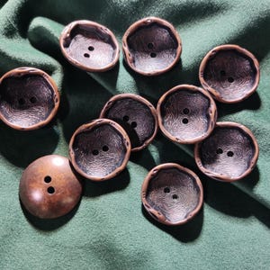 May include: A set of three ceramic mugs with a speckled, matte finish in cream, light brown, and dark brown. Each mug features a simple, minimalist design, ideal for tea or coffee.