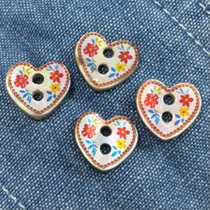 May include: Four heart-shaped buttons with a pearlescent finish, each featuring two central holes and a decorative border. The surface of each button is decorated with a colorful floral pattern consisting of red and yellow flowers with blue leaves.