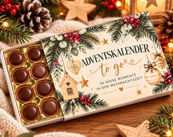 May include: A rectangular advent calendar box with a cream-colored lid featuring illustrations of pine branches, red berries, and ornaments. The text reads ADVENTSKALENDER to go 24 SÜSSE MOMENTE IN DER WEIHNACHTSZEIT. Inside are eight round chocolates.