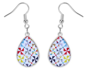 May include: A pair of silver teardrop earrings with a colorful geometric pattern on the front. The pattern is made up of red, yellow, blue, green, and white triangles.