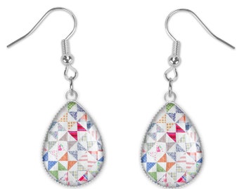 May include: A pair of silver teardrop earrings with a colorful patchwork quilt design. The earrings have a silver hook closure.