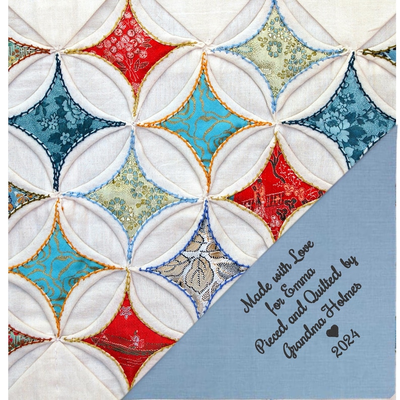 May include: A white quilt with a geometric pattern of red, blue, and gold fabric squares. The quilt is pieced and quilted by Grandma Holmes for Emma. The label is dated 2024.