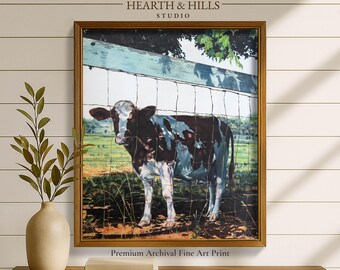 May include: A framed art print featuring a black and white cow standing in a grassy field behind a wire fence. The cow has a white face and dark patches on its body. The scene includes a wooden fence rail at the top and green pasture.