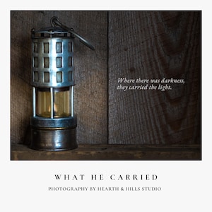 May include: A vintage metal miner's lamp with a glass reservoir, set against a rustic wooden background. The lamp has a handle and a rectangular grid design. Text reads: "Where there was darkness, they carried the light."