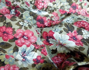 Puede incluir: Primer plano de una tela con un patrón floral. La tela es de color marrón claro con flores rosas, blancas y grises. Las flores están dispuestas en un patrón aleatorio y tienen un aspecto ligeramente descolorido.