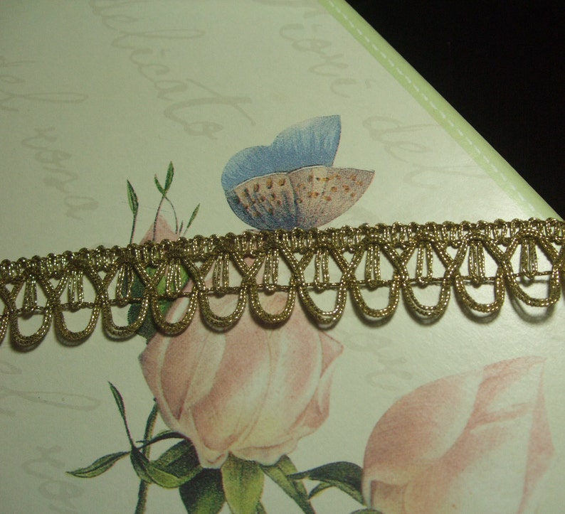 May include: Gold trim with a scalloped edge. The trim is made of a woven fabric with a metallic sheen.