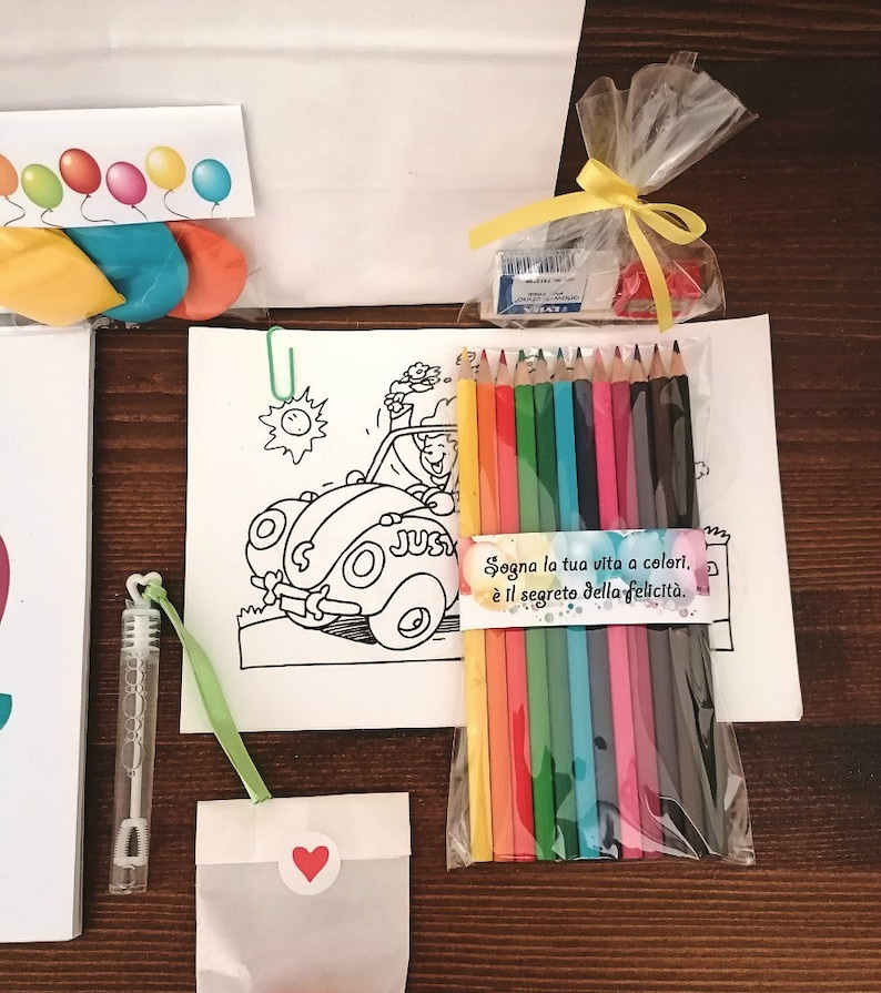 May include: A coloring book with a cartoon car and a set of colored pencils in a clear plastic bag. The bag has a tag that says "Sogno la tua vita a colori, e il segreto della felicita."