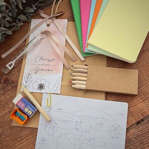 May include: A collection of party favors including small notebooks in various colors, a coloring book with safari animals, colored pencils, a pencil, eraser, and sharpener. A tag with the names Clarissa and Giacomo is also included.