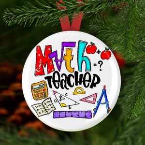 May include: A white, round Christmas ornament with the words "Math Teacher" in colorful letters. The ornament features math symbols, a calculator, apples, and a protractor. A red ribbon is attached for hanging.