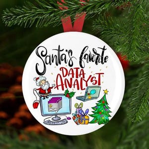 May include: White round Christmas ornament with a red ribbon. The ornament features a cartoon Santa Claus holding a computer mouse, a computer monitor with folders, a laptop, a Christmas tree, and presents. The text on the ornament reads "Santa's favorite data analyst".