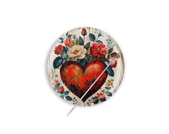 Può includere: Un elemento decorativo rotondo in legno con un design a cuore rosso e dettagli floreali. Il cuore è trafitto da una freccia d'argento. I fiori includono rose rosse, fiori bianchi e crema e accenti blu.