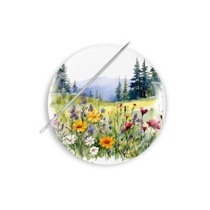 May include: A watercolor painting of a field of wildflowers in front of a mountain range. The flowers are in shades of yellow, pink, purple, and white. The mountains are in the background and are a light blue color.