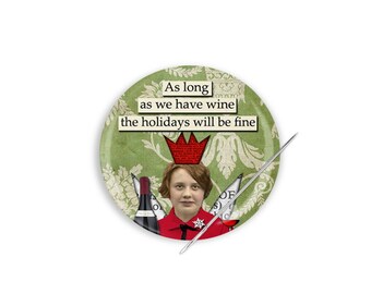 Può includere: Uno spillo rotondo con sfondo verde e un motivo floreale bianco. Lo spillo presenta una donna con una corona rossa e un vestito rosso, che tiene una bottiglia di vino. Il testo sullo spillo dice "As long as we have wine the holidays will be fine."