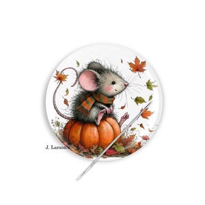 May include: A decorative plate featuring a charming mouse wearing a scarf, sitting atop an orange pumpkin. The mouse is surrounded by autumn leaves. The plate has the text "J. Larson" at the bottom.