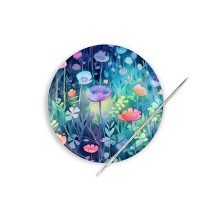 May include: A round needle minder with a watercolor design of colorful flowers on a dark blue background.