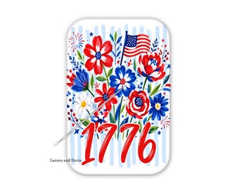 Può includere: Un magnete per aghi rettangolare con un design floreale patriottico nei colori rosso, bianco e blu, una piccola bandiera americana e il testo rosso 1776. Un ago da cucito argentato è fissato sulla superficie. Il testo Larson and Davis è visibile.