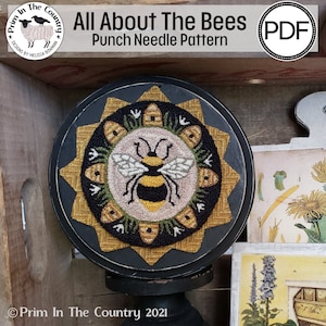 May include: A punch needle pattern featuring a bee with black and yellow stripes, surrounded by honeycombs and flowers. The pattern is titled "All About The Bees" and is a PDF download.
