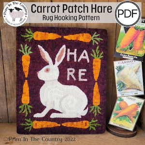 May include: A rug hooking pattern featuring a white rabbit with the words "HARE" in orange letters surrounded by a border of carrots. The pattern is titled "Carrot Patch Hare" and is available as a PDF download.