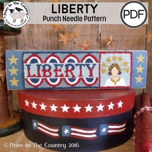 May include: A punch needle pattern for a patriotic wall hanging featuring the word "LIBERTY" in red, white and blue, a stylised image of a woman with a crown of stars, and stars on a blue background.