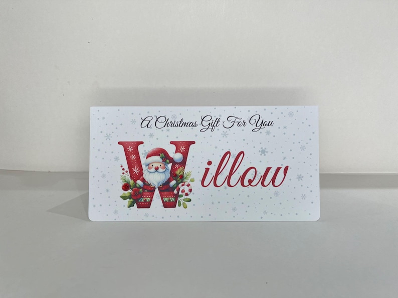 May include: A rectangular Christmas gift card with a festive design. The card features the text "A Christmas Gift For You" and the name "Willow" in red script. The letter "W" is decorated with Santa Claus.