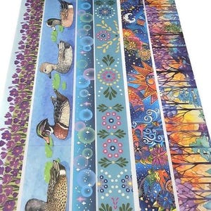 May include: A collection of decorative washi tape rolls with various designs. The tapes feature patterns including ducks, bubbles, floral motifs, and nature scenes with a color palette of blues, purples, and oranges. The tape is ideal for crafts and scrapbooking.