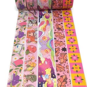 May include: A roll of decorative washi tape featuring various designs. The tapes include patterns of books, flowers, and whimsical illustrations in shades of pink, purple, and yellow. The tape is ideal for scrapbooking and crafting projects.