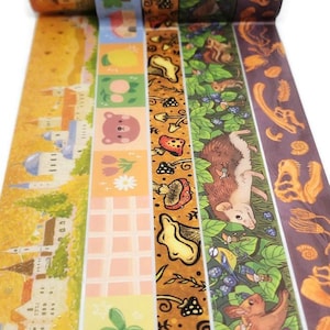 May include: A collection of decorative washi tapes with various designs. The tapes feature illustrations of castles, bears, mushrooms, and woodland creatures. The color palette includes shades of yellow, pink, green, and brown.
