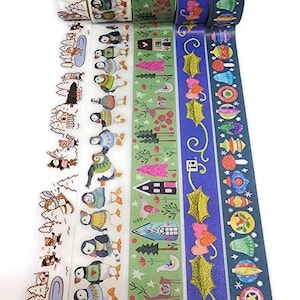 May include: A collection of decorative washi tapes with winter-themed designs. The tapes feature illustrations of penguins, snow-covered landscapes, houses, and holiday ornaments in various colors. The tapes are rolled and ready for use in crafts and gift wrapping.