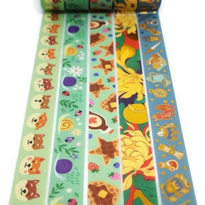 May include: Five rolls of washi tape with different designs. The designs include a green tape with a repeating pattern of a dog, a snail, and flowers, a green tape with a repeating pattern of a waffle, strawberries, and blueberries, a yellow tape with a repeating pattern of a flower, a red tape with a repeating pattern of a flower, and a blue tape with a repeating pattern of a dragon, a sword, and a potion bottle.