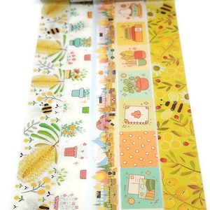 May include: A set of five washi tapes with various designs, including bees, flowers, lemons, and geometric patterns. The tapes are all yellow and white with a variety of colors and patterns.