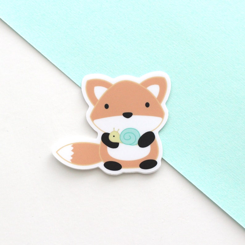 Vinyl sticker of a cartoon style orange fox holding a little snail
