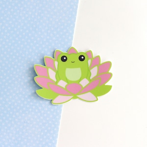 Vinyl sticker of a cartoon style green frog sitting on a lotus flower