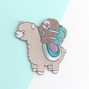 May include: Embroidered patch featuring a brown alpaca with a brown sloth riding on its back. The sloth is wearing a blue backpack. The alpaca is standing on a light blue and purple background.