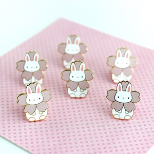 Six enamel pins of a little bunny wearing a pink sakura flower costume