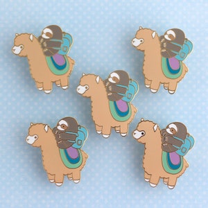 May include: Five enamel pins featuring a brown alpaca with a brown sloth riding on its back. The alpaca is wearing a blue backpack and the sloth is wearing a purple backpack. The pins are on a light blue background.