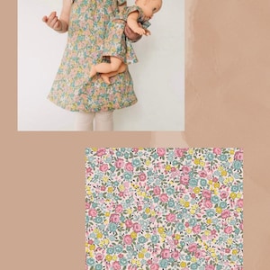 May include: A dress with a floral pattern featuring small pink, blue, and yellow flowers on a light background. The dress has short flutter sleeves and a round neckline. A matching doll dress is included. The text PETITE FLEUR PINK is visible.