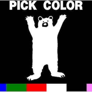 May include: White silhouette of a bear standing on its hind legs with its arms raised in the air. The bear is on a black background with the text "PICK COLOR" above it.