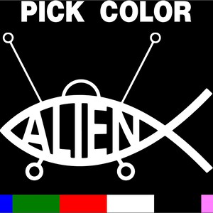 May include: A white silhouette of a flying saucer with the word "ALIEN" written inside. The saucer has two antennas and a tail fin. The image is on a black background with the words "PICK COLOR" at the top.