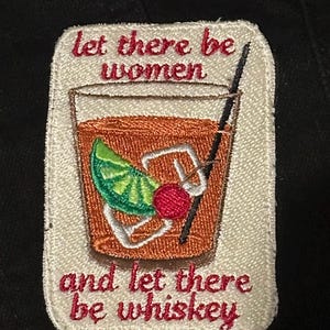 Pu&ograve; includere: Toppa ricamata con un design a cocktail. La toppa presenta una bevanda con una fetta di lime e ciliegia, una cannuccia e il testo "Let there be women and let there be whiskey" in rosso.